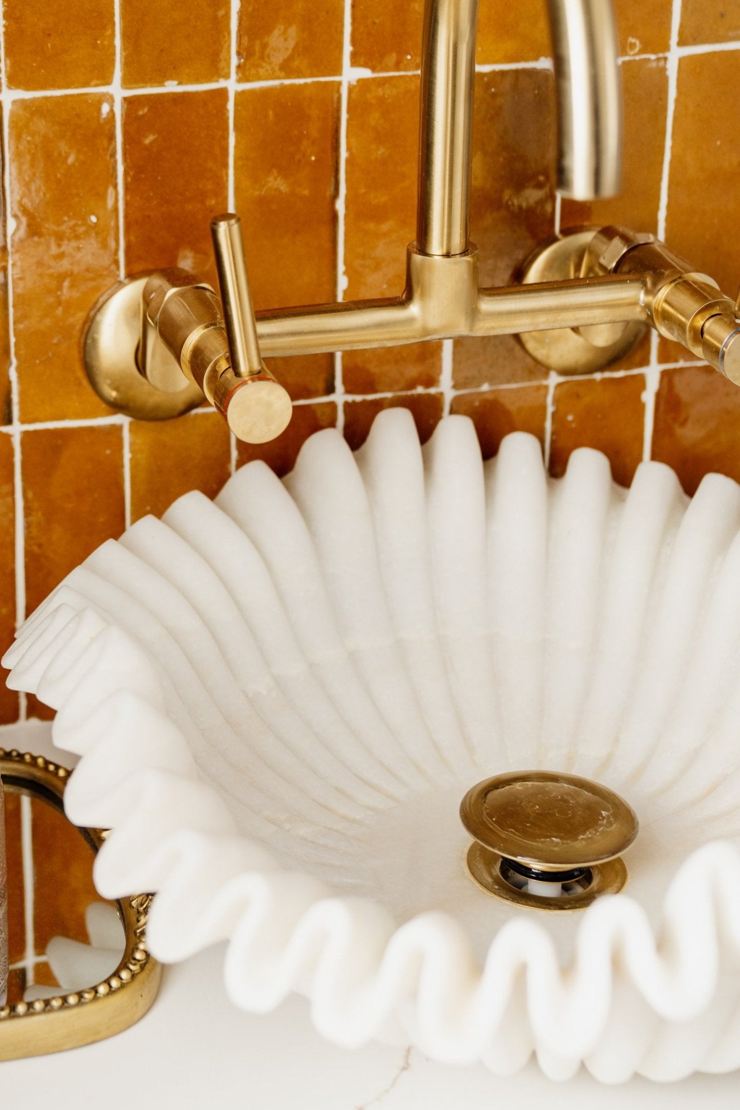 Designer vessel sink in white marble with brass faucet