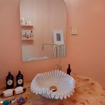 Ripple marble sink installed in luxury bathroom with gold faucet